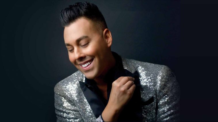 Smiling man in silver jacket and black hair Cade Bittner