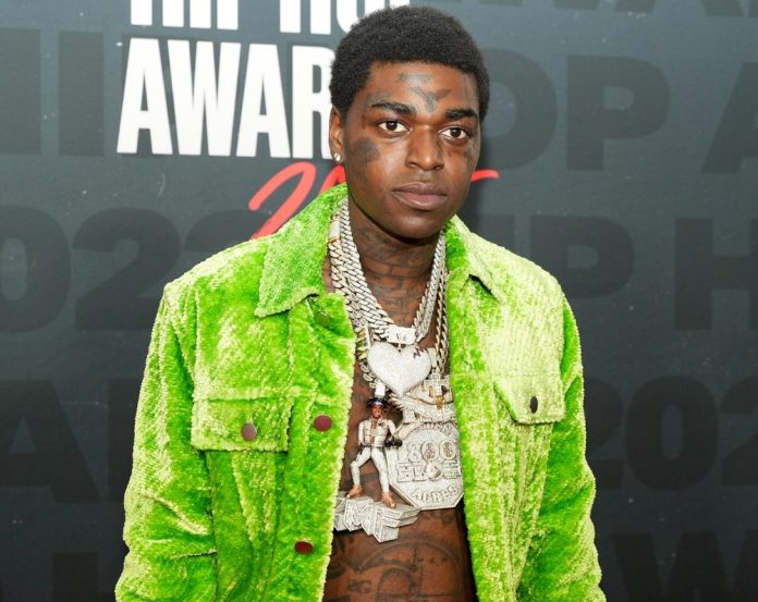 who is kodak black. image of the rapper arriving for an event in a lime green suit