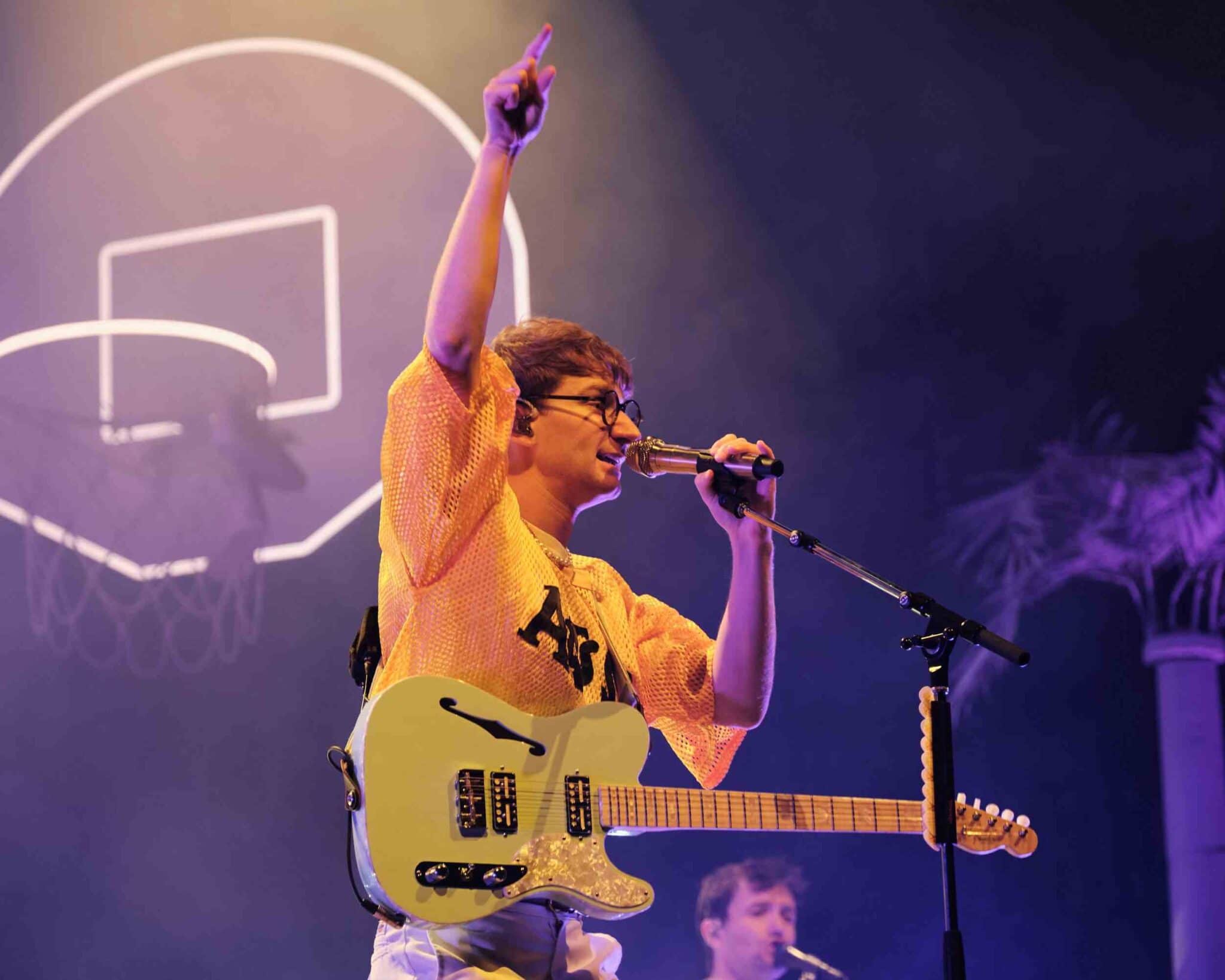 Lead Singer Dave Bayley sings on stage with his arm in the air