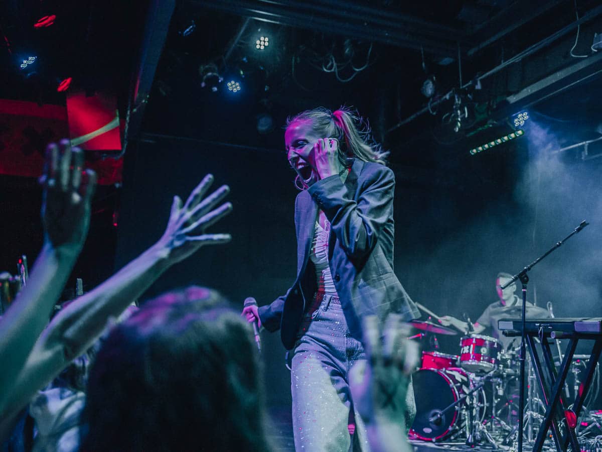 Maude Latour shows surprise and joy to the fans cheering her on stage