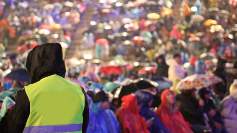Fans wearing raincoats at a large outdoor