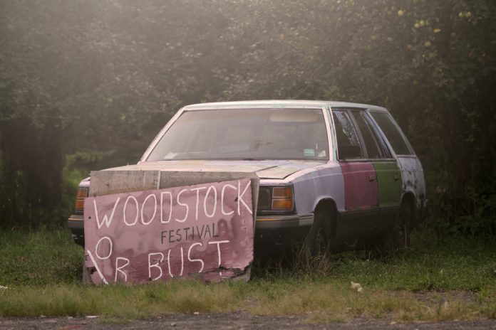 old woodstock sign leaning against a car