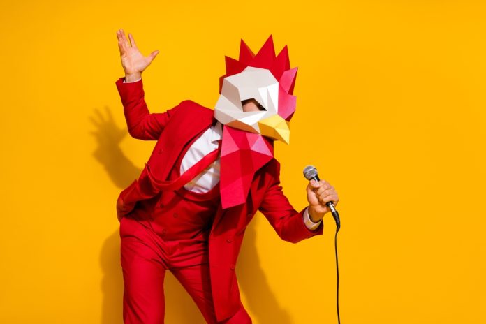 the masked singer a man in a chicken costume singing