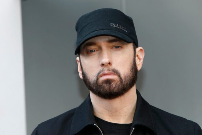eminem wearing a hat in front of a gray background