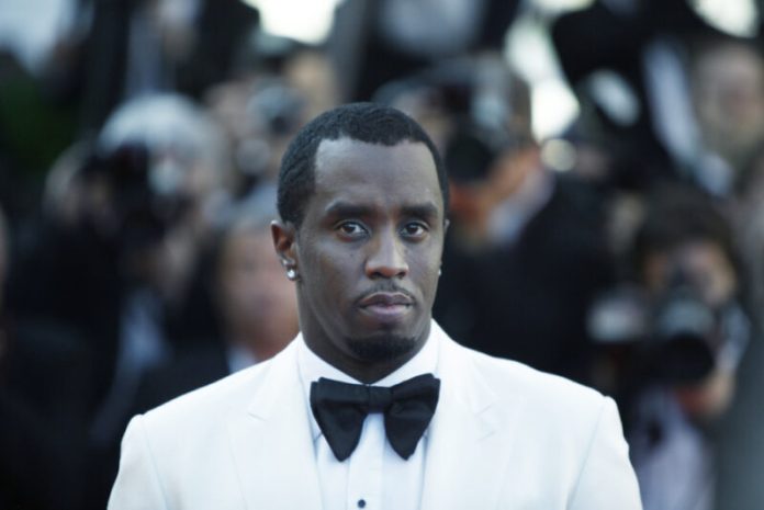 P diddy in a white suit and black bowtie on the red carpet