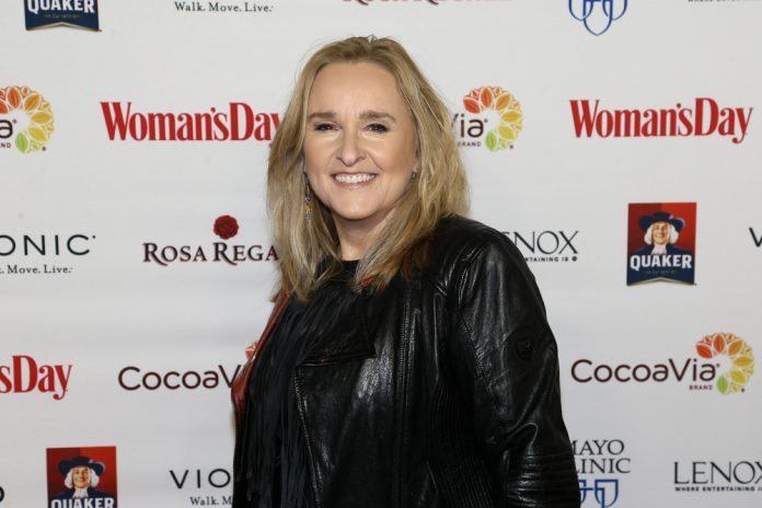 melissa etheridge on the red carpet wearing a black shirt and black jacket