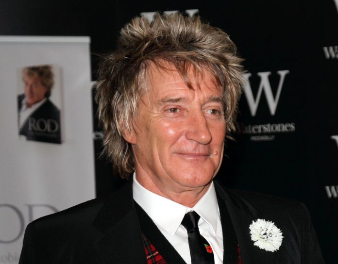 singers diagnosed with cancer rod stewart in a suit with a white flower on the lape