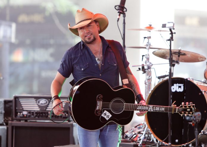 jason aldean's net worth: jason aldean on stage with a black guitar performing