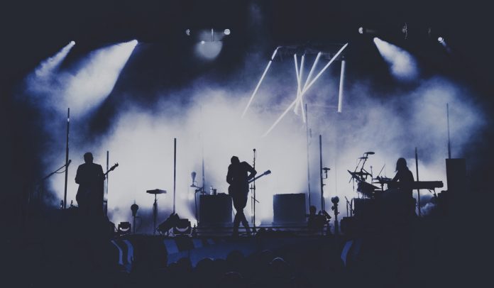 ways to score cheap concert tickets a band performing on stage band silhouette