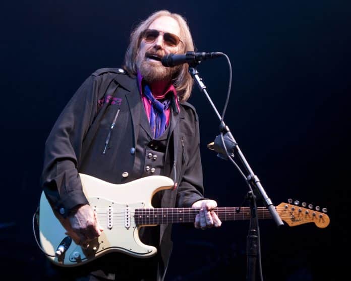 tom petty singing on stage and playing guitar