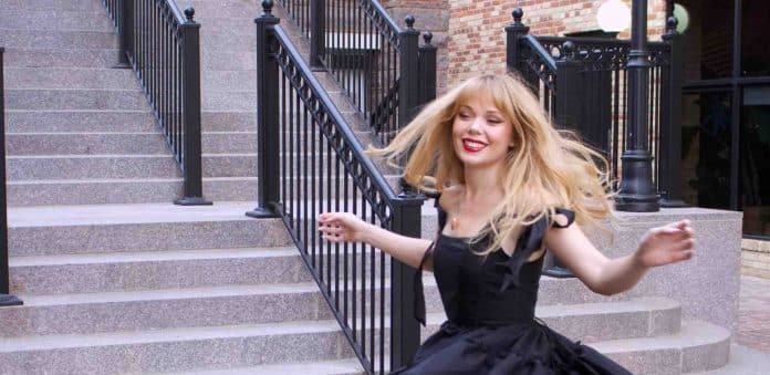 Singer poses in front of a staircase