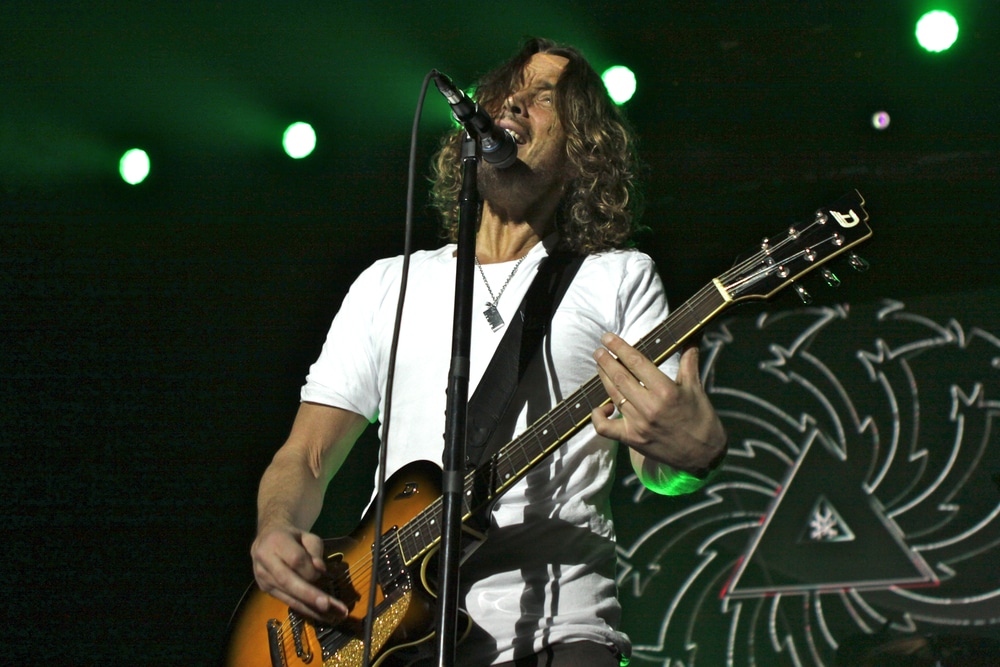 how did chris cornell die? chris cornell on stage singing and playing guitar