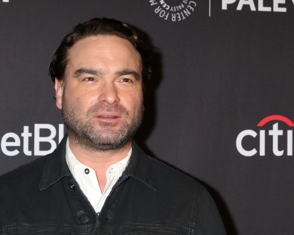 johnny galecki arriving at an event in a dark shirt