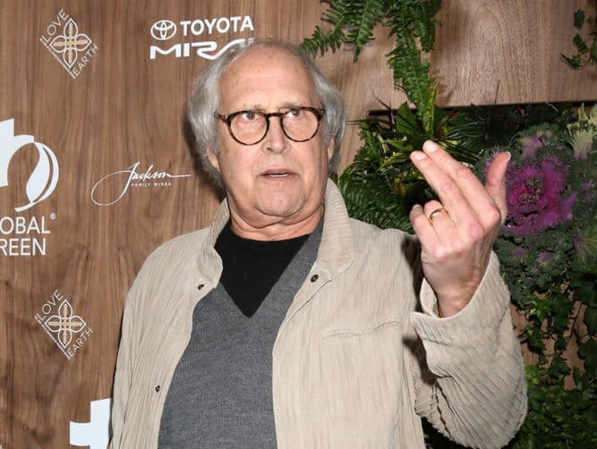 celebrities who are taller than you expected chevy chase making a weird face on the red carpet