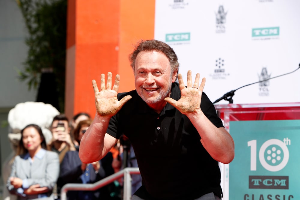 billy crystal at an event making a goofy face during a speech