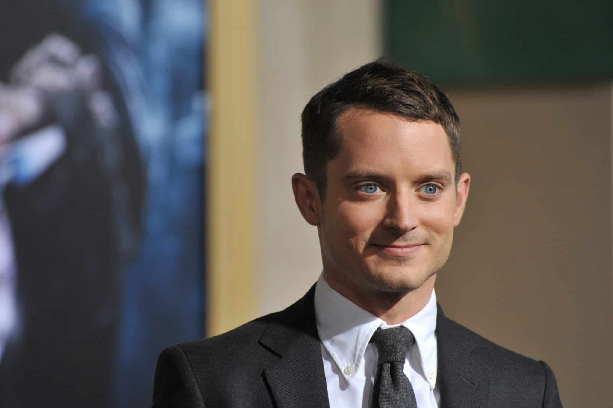 elijah wood arrives for an event in a suit