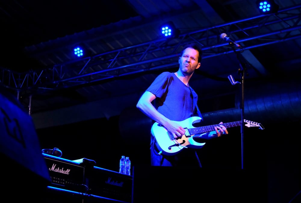 tall musicians paul gilbert on stage playing guitar