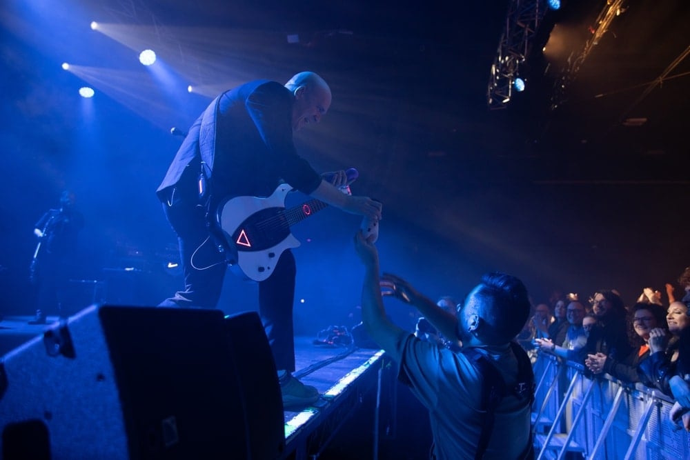 devin townsend getting something from the crew while performing
