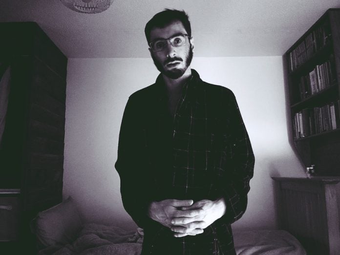 artist Zachary Mason standing in bedroom